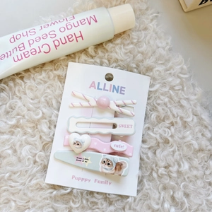 Dettaglio di un set di fermagli per capelli con gatti e motivi a strisce rosa e cuori