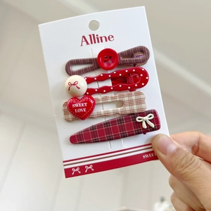 Set of four red plaid hair clips with bow, heart and dot patterns on white background