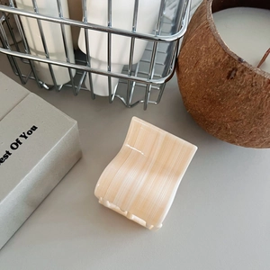Elegant beige textured claw clip for ponytail on aesthetic neutral lifestyle background