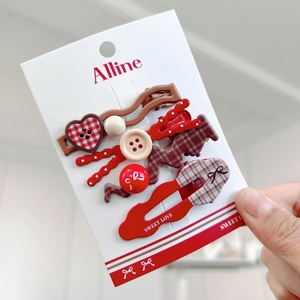 Detail view of 5-piece red plaid and heart hair clips set on a display card