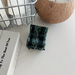 Detailed view of large marble texture hair claw clip with acetate finish and metal spring