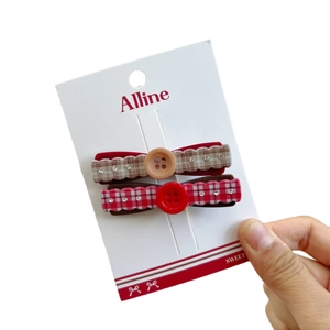 Plaid bow hair clips set with sparkling rhinestones for women on a display card
