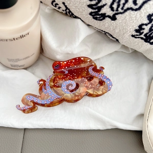 Octopus shaped acetate hair claw clip with amber marble texture and pink dots
