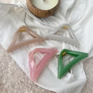 Set of four pastel geometric hair claws in beige, white, pink, and green colors