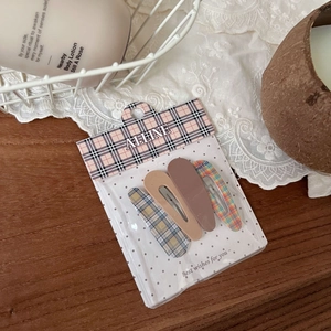 Close-up of a 4-piece cute hair clip set with solid brown and plaid patterns