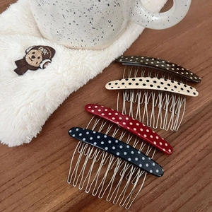 Detailed view of four-piece polka dot hair combs with wavy metal teeth for secure grip