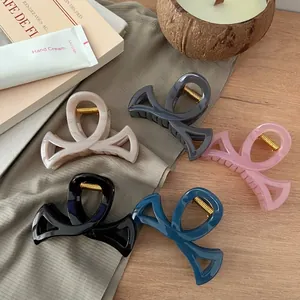 Lot de pinces à cheveux nśud évidé de 8,5 cm en cinq couleurs sur surface en bois