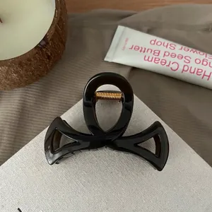 Vue détaillée de la pince à cheveux ambre foncé avec finition brillante et ressort doré