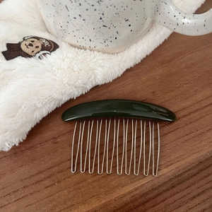 Detail of green acetate hair comb with FANRCE Handmade gold logo and silver metal teeth