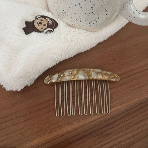 Detailed view of vintage tortoiseshell acetate hair comb with thirteen silver metal teeth