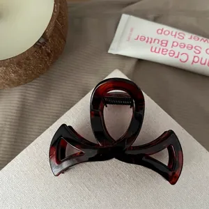Détail de la pince à cheveux noeud de 8,5 cm avec motif écaille de tortue et ressort noir