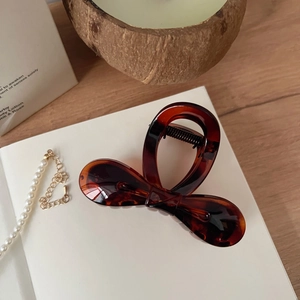 Détail d'une pince à cheveux de 8 cm en ambre foncé avec motif écaille de tortue