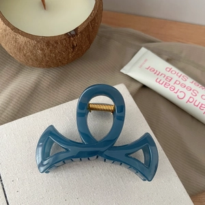 Détail d'une pince à cheveux élégante bleu foncé avec ressort en métal doré