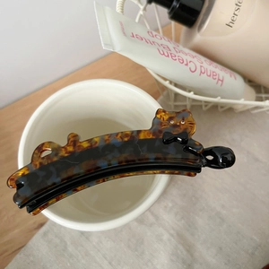 Détail d'une pince à cheveux chat en écaille de tortue décorée d'un petit nœud noir