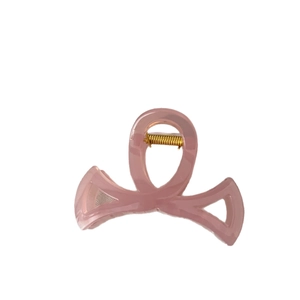 Pince à cheveux nœud rose translucide avec ressort en métal doré sur fond blanc pur