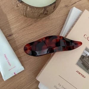 Close-up of tortoise shell resin hair claw clip with a polished finish on vintage books