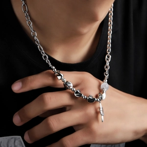 Silver chain necklace featuring starburst beads and feather pendant on a male model