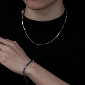 Irillerende hematiet ketting en armband set met geometrische kralen op een model