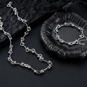 Miteinander verbundenes silbernes Titanschmuckset mit gewelltem Perlenkettendesign