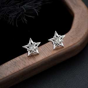 Boucles d'oreilles étoile à couches avec pierre scintillante sur plateau en bois