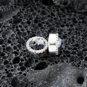 Boucles d'oreilles magnétiques en argent avec cristaux noirs et blancs sur roche lave