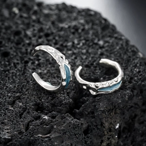 Mint green lava texture ear cuff in silver finish on black volcanic stone background