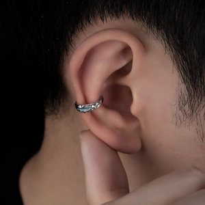 Macro detail of silver non-piercing ear cuff featuring irregular lava texture on model