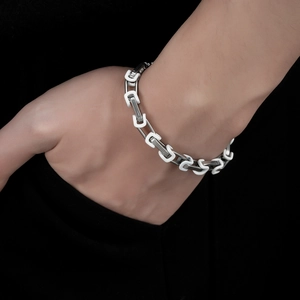 Bracciale unisex in acciaio al titanio con maglie argentate ed elementi bianchi a forma di U
