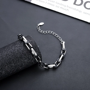 Dettaglio del bracciale a catena industriale argento e nero con maglie e targhetta
