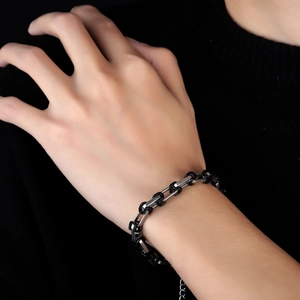 Bracciale a catena in acciaio al titanio bicolore nero e argento indossato al polso