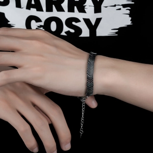 Detail view of hematite V-shaped arrow link bracelet with lobster clasp on male wrist