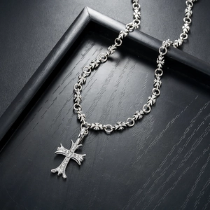 Gothic cross necklace in silver finish with pavé set crystals on a black wood display