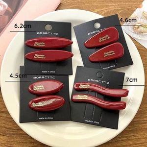 Set of four red acetate hair clips in various shapes with sizes from 4.5cm to 7cm