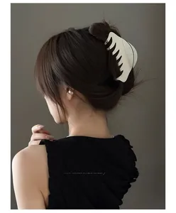 Détail d'une grande pince à cheveux en acétate crème pour un chignon français élégant