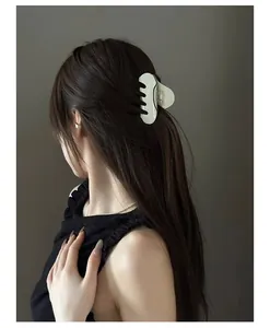 Détail de la pince à cheveux en acétate crème portée pour un style élégant et moderne