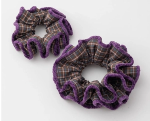 Detail of autumn plaid scrunchies with purple plush edges in a two-piece set