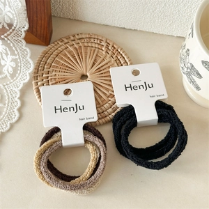 Detailed close-up of ribbed seamless elastic hair bands in black and earth tones