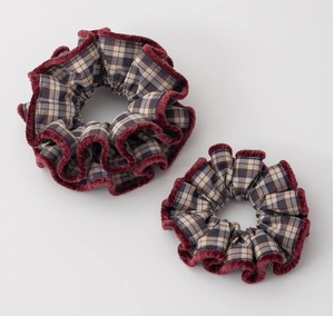 Detailed macro view of plaid fabric scrunchies with red velvet trim and texture