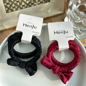 Detail of red and black satin bow scrunchies with elegant silk texture on display cards
