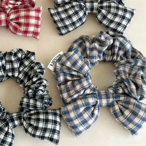 Plaid checkered hair scrunchies with bow tie detail in red blue and black patterns