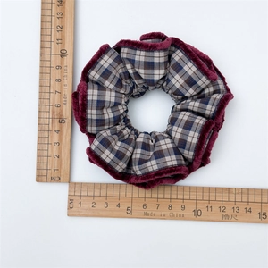 Plaid checkered hair scrunchie with plush burgundy trim measured on a scale