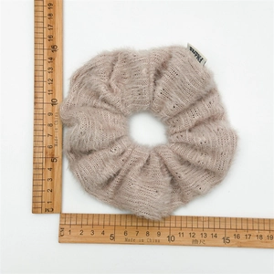 Chouchou en tricot doux et duveteux marron clair avec étiquette sur fond blanc