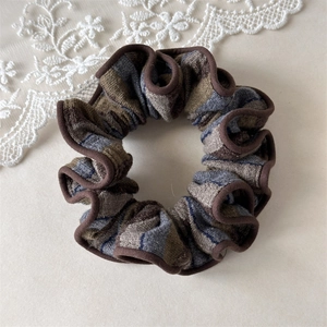 Dettaglio di scrunchie vintage a righe con trama a maglia ed elastico spesso