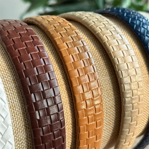 Plaid checkered leather wide headbands in assorted colors displayed on a woven stand