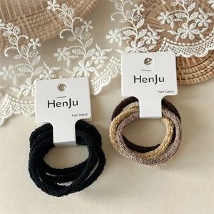 Detailed view of high-elasticity knitted seamless hair ties in black and earthy tones