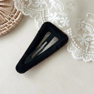 Detail of a minimalist black flocked leopard print BB hair clip with metal spring mechanism