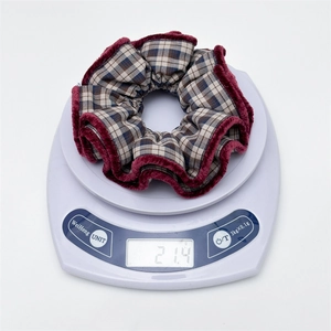 Detail shot of a plaid scrunchie with purple velvet trim on a scale weighing 21.4g