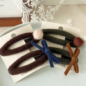 Gros plan de barrettes d'hiver en feutre marron et vert avec nœuds et boules de peluche