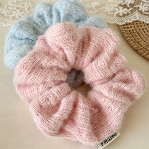 Détail de chouchous en tricot bleu et rose doux avec texture pelucheuse et étiquette tissu