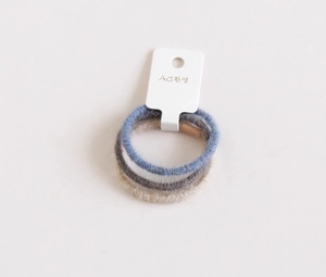 Dettaglio di elastici per capelli ad alta elasticità in blu, grigio e beige morbidi